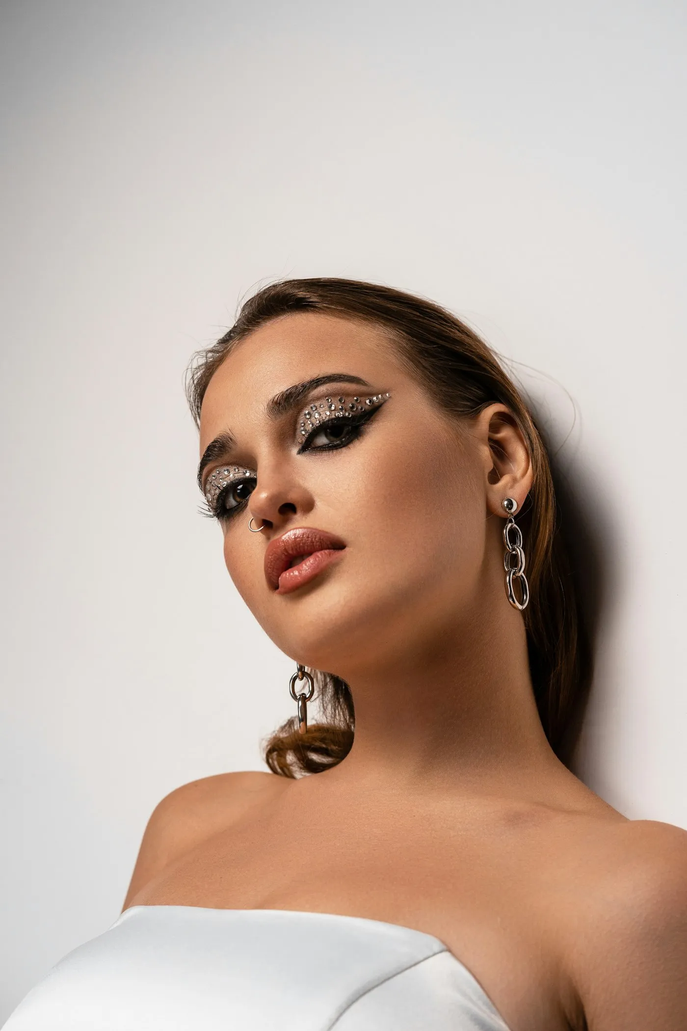 Rhinestone eye make-up with silver chain earrings